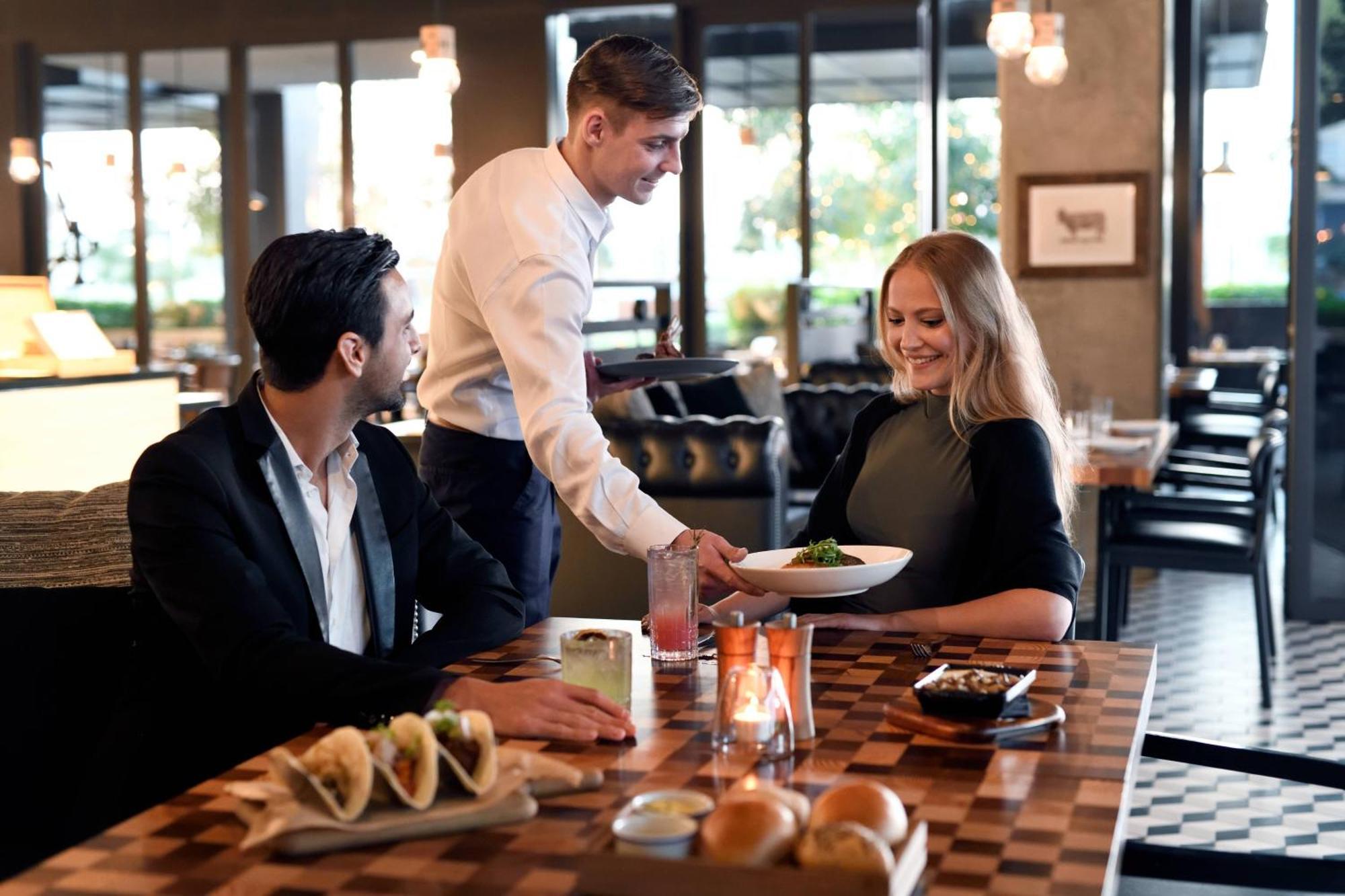La Ville Hotel & Suites City Walk Dubai, Autograph Collection Exterior foto A waiter serving a couple